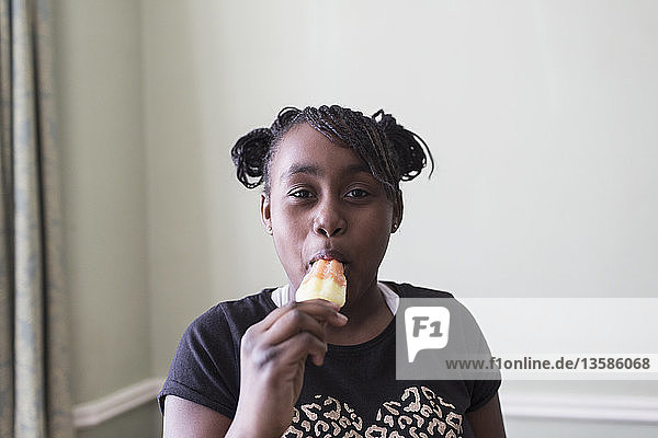 Porträt eines selbstbewussten Mädchens  das aromatisiertes Eis isst