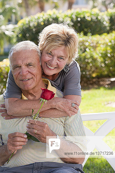 Porträt einer älteren Frau  die einen Mann von hinten umarmt
