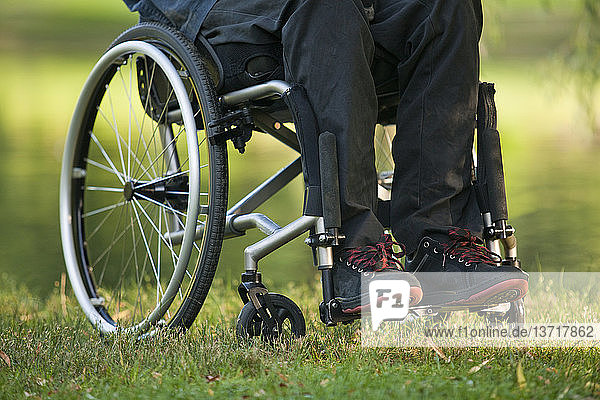 Low section view of a man in wheelchair with spinal cord injury in a park