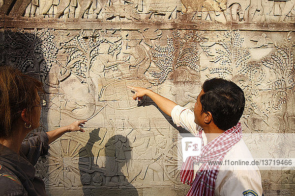 Touristenführer mit Elefanten und Kriegern. Reliefskulptur auf der östlichen Außengalerie des Bayon.
