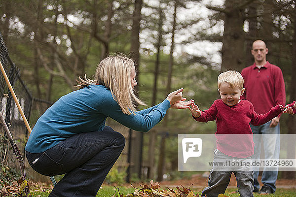 Frau gebärdet das Wort ´Help´ in amerikanischer Zeichensprache  während sie mit ihrem Sohn in einem Park kommuniziert