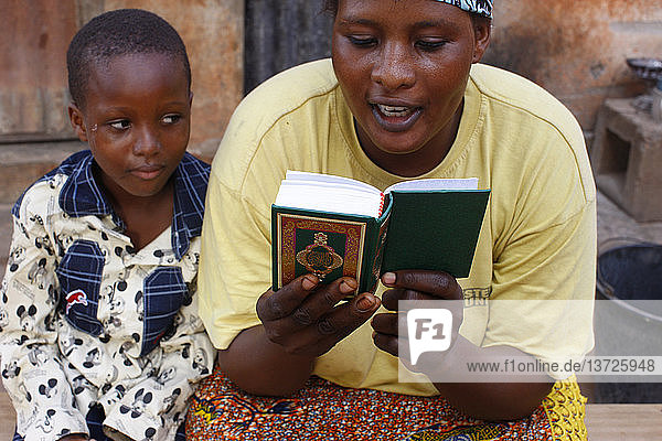 Afrikanische Mutter liest den Koran.
