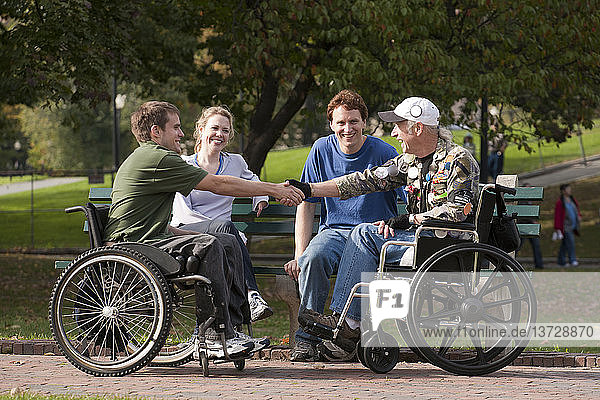 Veteranen treffen Freunde und schütteln sich im Park die Hände