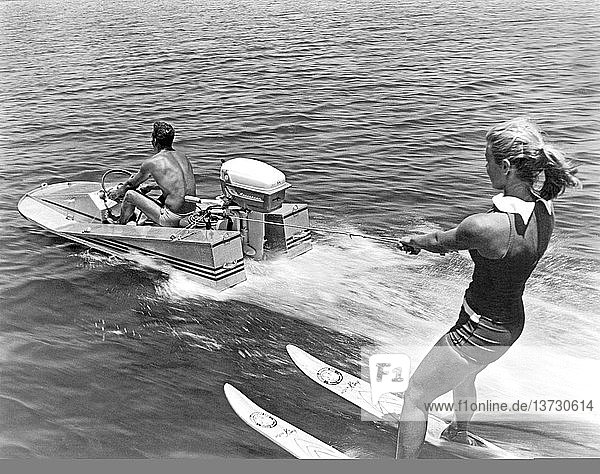 Vereinigte Staaten: ca. 1964 Ein Mädchen fährt Wasserski hinter einem Mini-Speedboot.