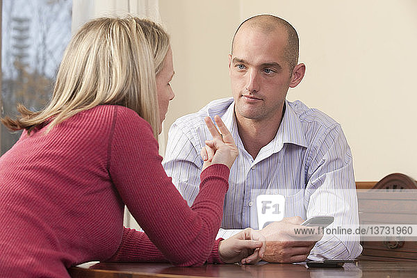 Woman signing the phrase ´Look at me´ in American Sign Language while communicating with a man
