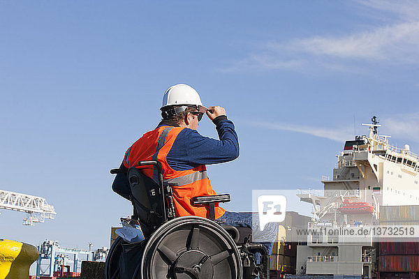 Transportingenieur im Rollstuhl bei der Inspektion von Schiffscontainern im Verschiffungshafen