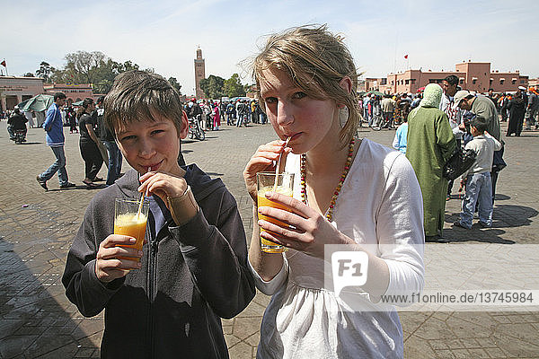 Children drinking fresh orange juice in Place Gema el-Fna  Marrakech  Morocco