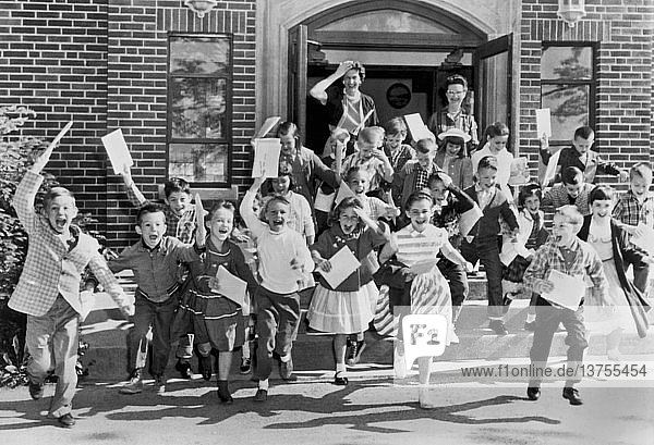 Mt. Carmel  Ohio: ca. 1963 Zweitklässler eilen am letzten Schultag zur Tür hinaus  während ihre Lehrerin sich von ihnen verabschiedet.