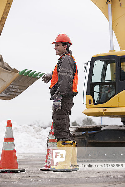 Transportation engineer directing an earth mover at a construction site