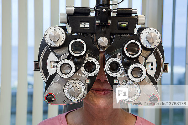 Woman getting eye exam with a phoropter