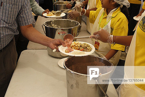 Freiwillige Helfer servieren Mahlzeiten beim Janmashtami-Fest im Bhaktivedanta Manor ISKCON (Hare Krishna)-Tempel