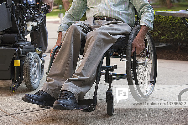 Ein Mann mit einer Rückenmarksverletzung sitzt im Rollstuhl