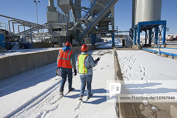 Zwei Ingenieure bei der Untersuchung einer Industrieanlage im Winter