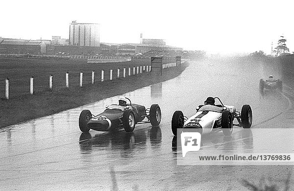Stirling Moss in a Walker Lotus 18-21 passing Ian Burgess in Camoradi Lotus 18 with special nose. British Grand Prix  Aintree  England 15 July 1961.