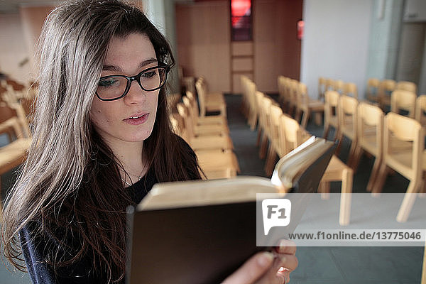 Junge Frau liest in einer Kirche in der Bibel.
