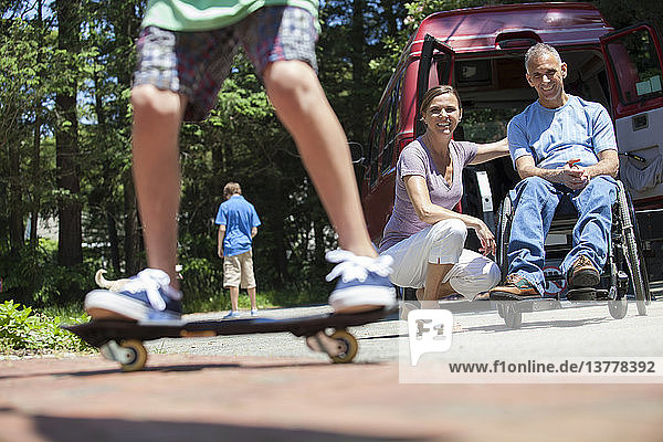 Ehepaar beobachtet seinen Sohn auf dem Skateboard