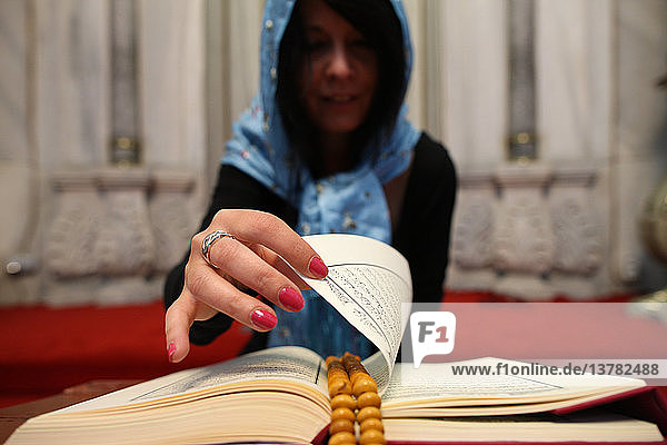 Frau liest den Koran in einer Moschee