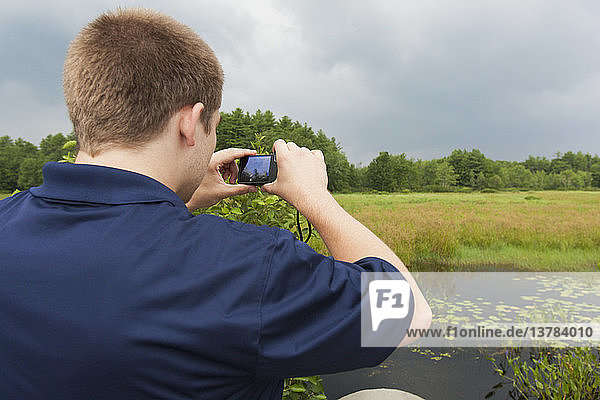 Public works engineer photographing swamp near reservoir  Portland  Maine  USA