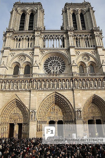 Menschen versammeln sich vor der Kathedrale Notre Dame de Paris  um das erste Läuten der neuen Glocken zu hören.