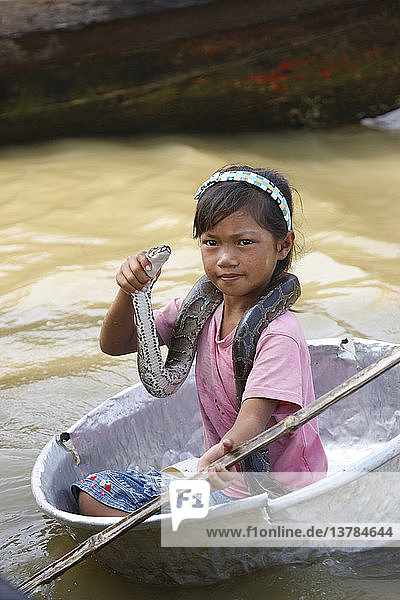 Child showing snakes to tourists on Tonle Sap lake