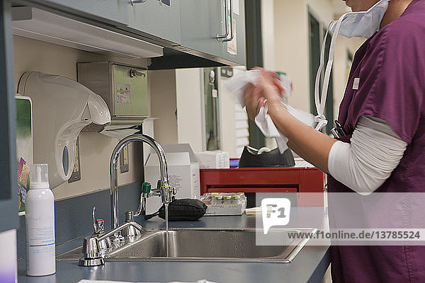 Krankenschwester wischt sich nach dem Waschen die Hände ab
