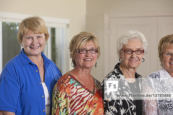Portrait of four senior female friends smiling together