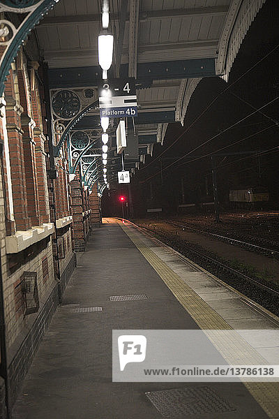 Verlassener Bahnsteig eines Bahnhofs bei Nacht