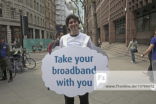 Lächelnder Mann mit einer Sandwich-Tafel für mobiles Breitband  London  England