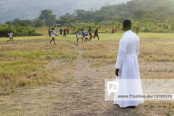 Catholic priest watching a soccer game