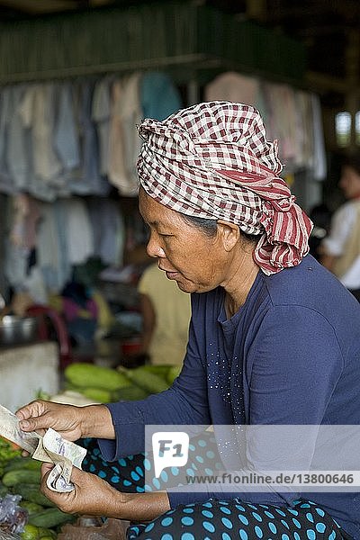 Verkäuferin beim Geldzählen auf dem Markt von Kep.