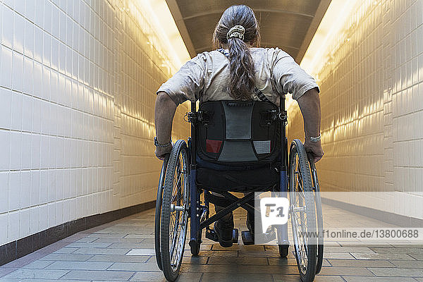 Frau mit Querschnittslähmung im Rollstuhl beim Betreten einer U-Bahn-Station  Boston  Massachusetts  USA