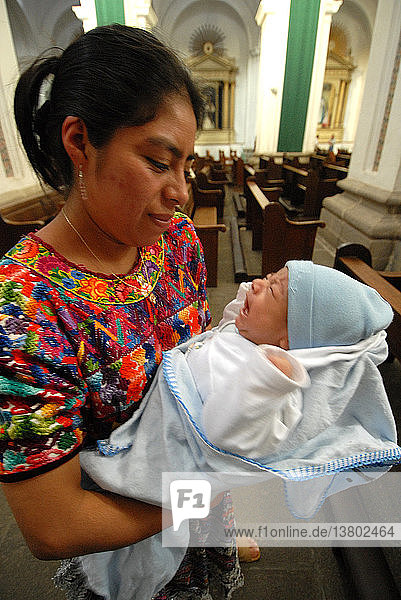 Frau und Baby in der Kirche von Santiago Atitlan