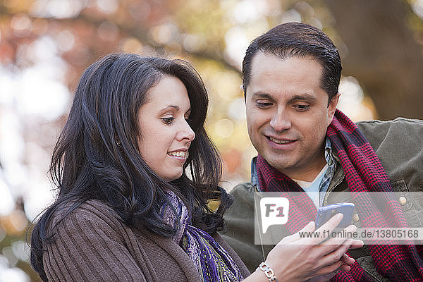 Couple text messaging on a mobile phone
