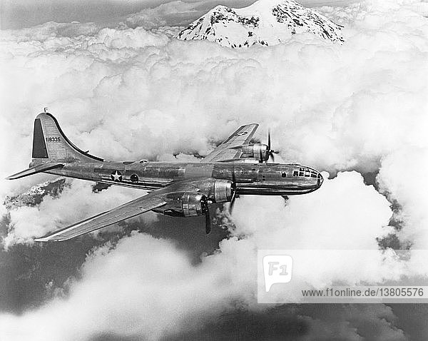 United States: c. 1944 A U.S. Air Force Boeing B-29 Superfortress bomber flying above the clouds and mountains.