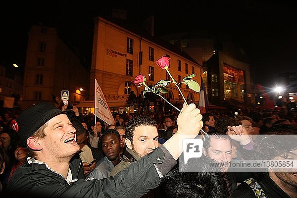 Junge Leute auf der Straße halten Rosen und feiern den Sieg von Francois Hollande über die Bastille.