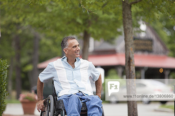 Mann mit Querschnittslähmung im Rollstuhl beim Einkaufen
