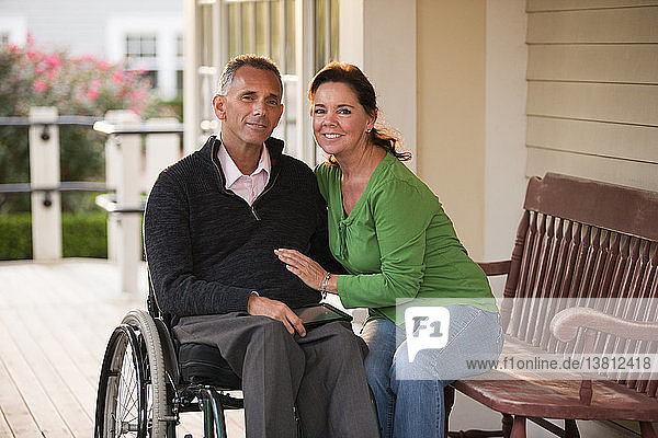 Porträt eines glücklichen Paares mit dem Mann im Rollstuhl