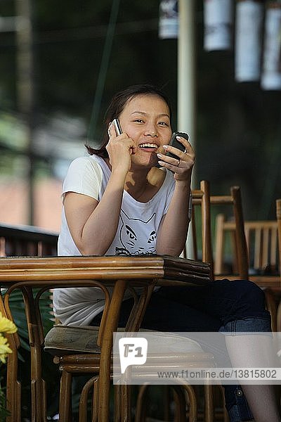 Junges Mädchen mit zwei Telefonen  Ho Chi Minh Stadt  Vietnam.