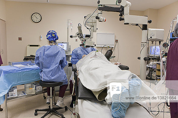 Chirurgische Technikerin übergibt dem Arzt ein Instrument während einer Kataraktoperation