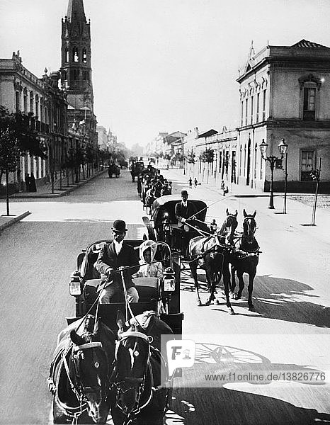 Santiago  Chile: c. 1910 Tourists in carriages driving down Santiago´s main street