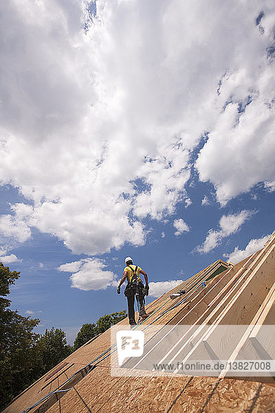 Hispanischer Zimmermann auf dem Dach eines im Bau befindlichen Hauses