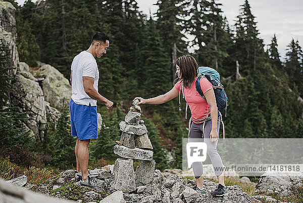 Couple hiking  stacking rocks