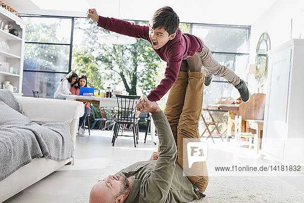 Vater und Sohn spielen auf dem Boden im Wohnzimmer