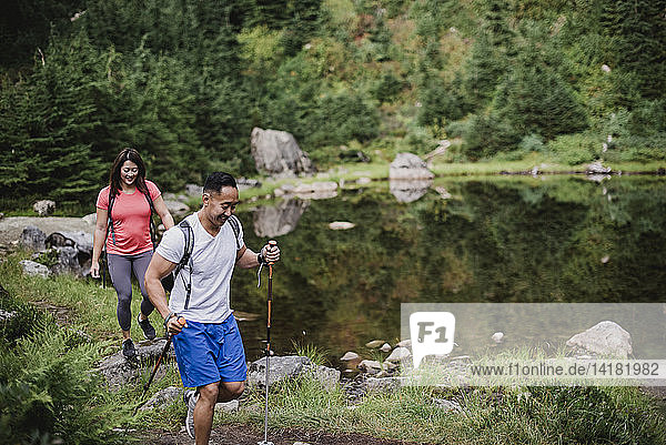 Couple hiking along lake in woods