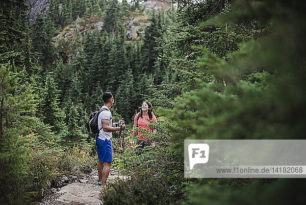 Couple hiking on remote trail in woods