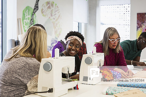 Female fashion designers working at sewing machines in studio