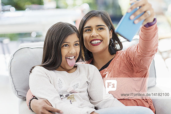 Verspielte Mutter und Tochter nehmen Selfie mit Kamera-Handy