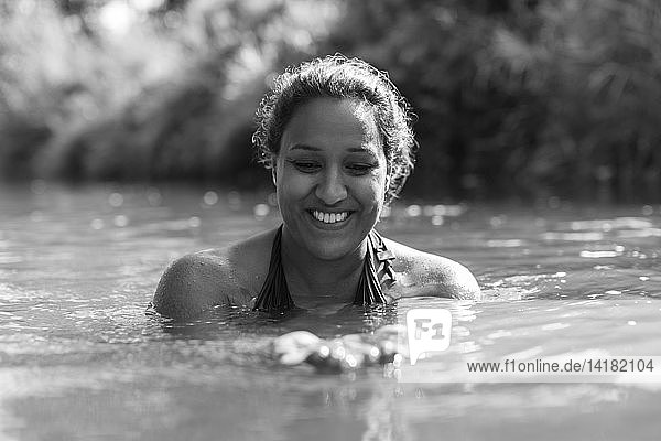 Glückliche Frau beim Schwimmen im sonnigen Fluss