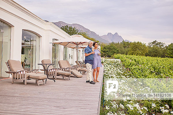 Älteres Paar trinkt Champagner auf der Terrasse des Resorts