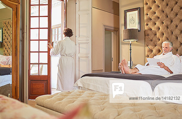 Couple in bathrobes relaxing in hotel room